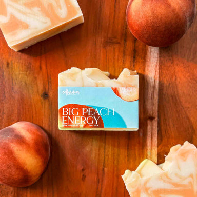 Bar of soap labeled 'Big Peach Energy' with peaches on a wooden surface