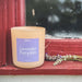Candle labeled 'Lavender Pumpkin' on a red surface with blurred background