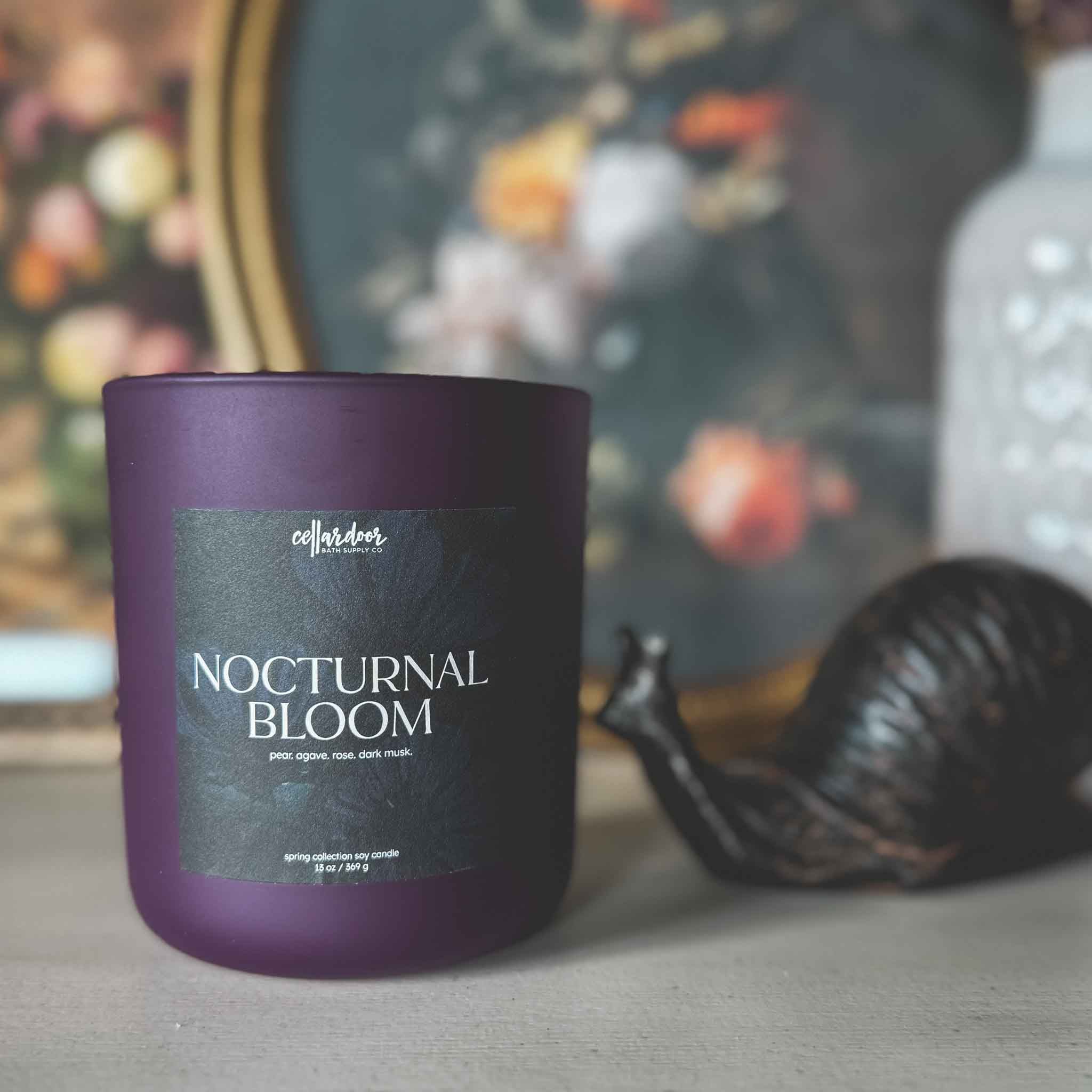 Purple candle labeled 'Nocturnal Bloom' with a blurred background