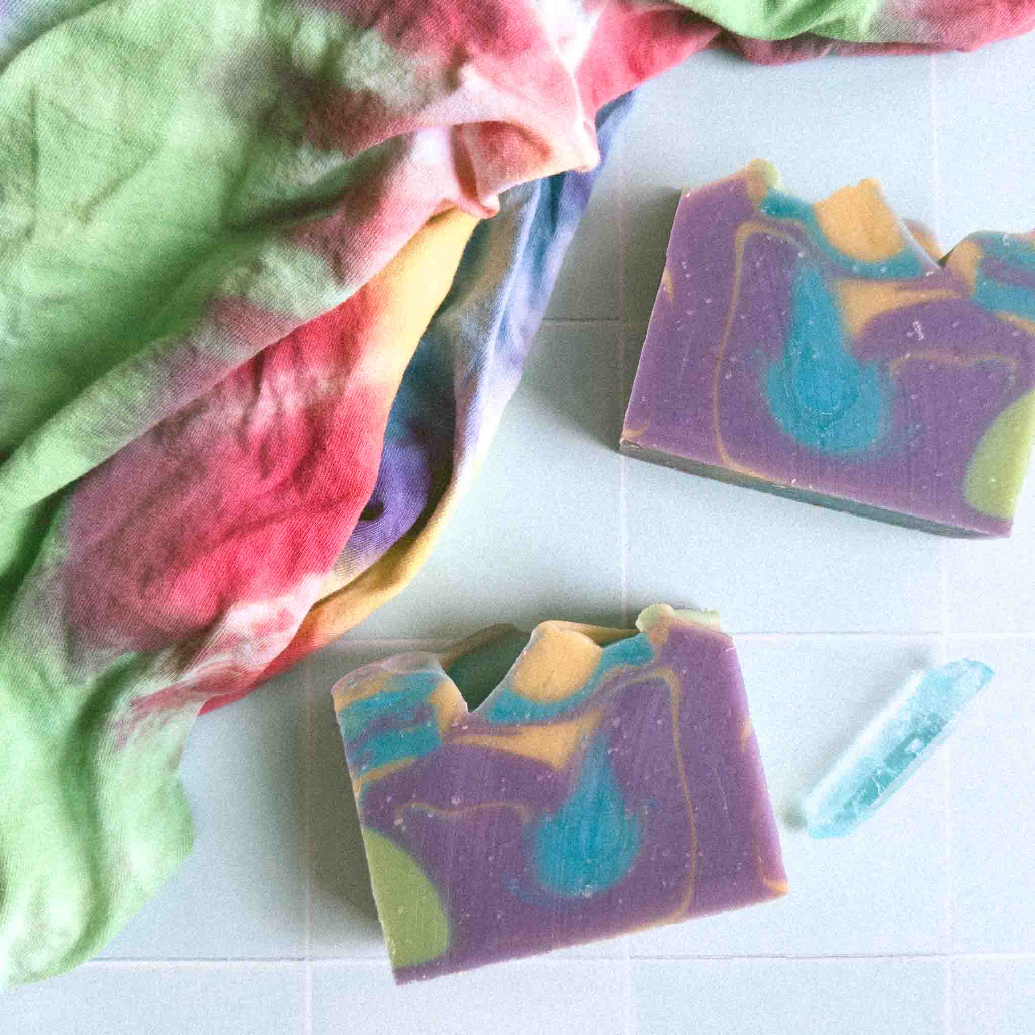 Colorful soap bars with a tie-dye fabric in the background