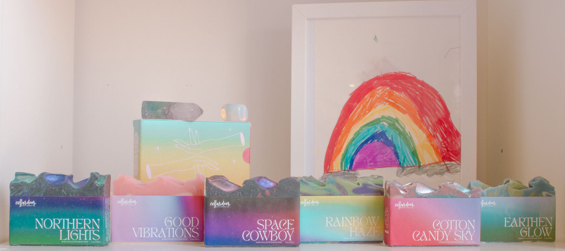 Assorted soaps from the Aura Collection are displayed on a decorative shelf.