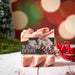 A bar of Winter Berry soap sits against a stylized background.